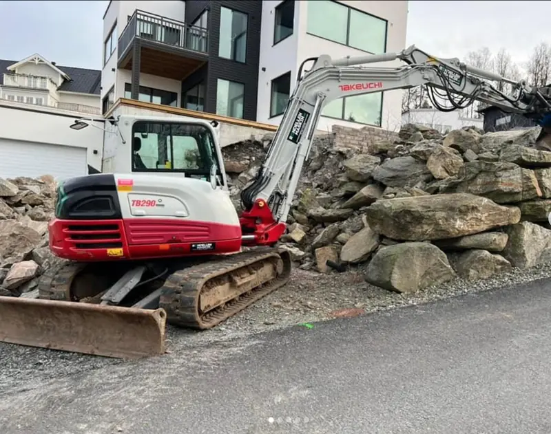 Grävmaskin vid markarbete med större stenar