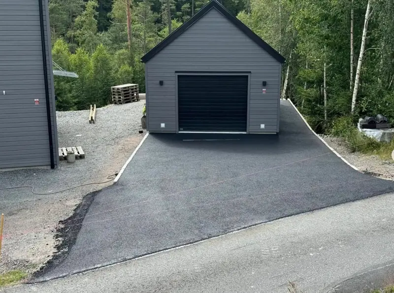 Färdig mörk uppfart framför garage